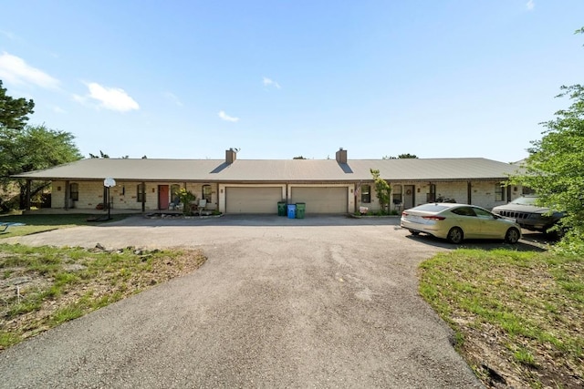 201 Loving Trl, Dripping Springs, TX 78620 - ranch-style house featuring an attached garage, asphalt driveway, and a chimney