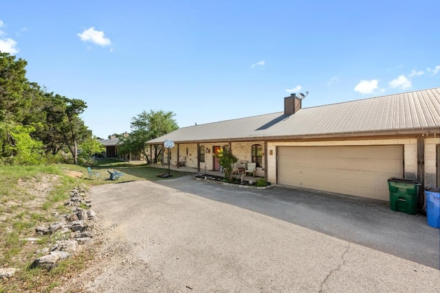 201 Loving Trl, Dripping Springs, TX 78620 - ranch-style home featuring a garage, a chimney, metal roof, and driveway