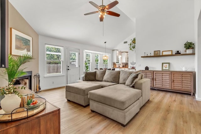 206 Quail Cir, Hutto, TX 78634 - living area with light wood-style floors, ceiling fan, high vaulted ceiling, and a fireplace