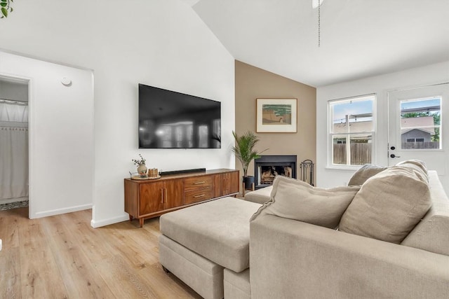206 Quail Cir, Hutto, TX 78634 - living area featuring lofted ceiling, light wood finished floors, and a fireplace