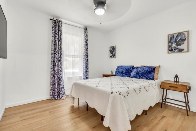 bedroom featuring wood finished floors, baseboards, and a ceiling fan