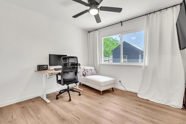 office area featuring light wood-style flooring, a ceiling fan, and baseboards