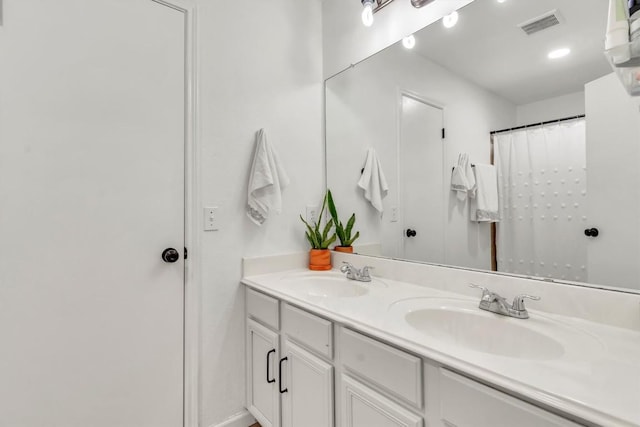 bathroom with double vanity and baseboards