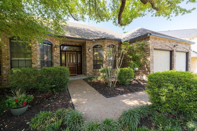 7303 Bluntleaf Cv, Austin, TX 78750 - entrance to property with brick siding, a garage, and a shingled roof