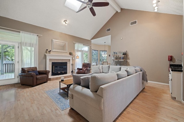 7303 Bluntleaf Cv, Austin, TX 78750 - living room with a ceiling fan, beamed ceiling, light wood-style flooring, healthy amount of natural light, and high vaulted ceiling