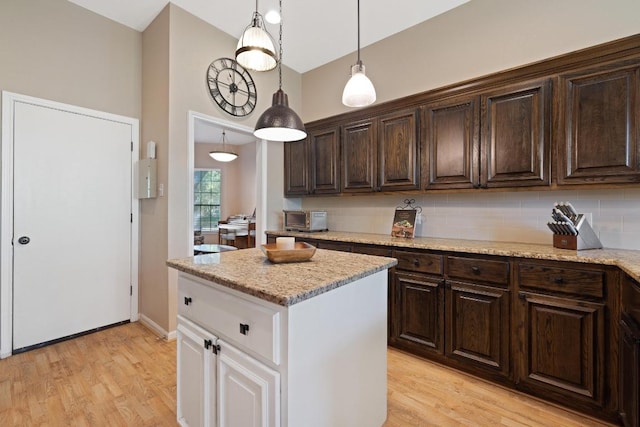 7303 Bluntleaf Cv, Austin, TX 78750 - kitchen with white cabinetry, dark brown cabinetry, light wood-style flooring, and high vaulted ceiling