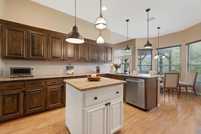 7303 Bluntleaf Cv, Austin, TX 78750 - kitchen featuring stainless steel dishwasher, healthy amount of natural light, light wood-style floors, and white cabinetry