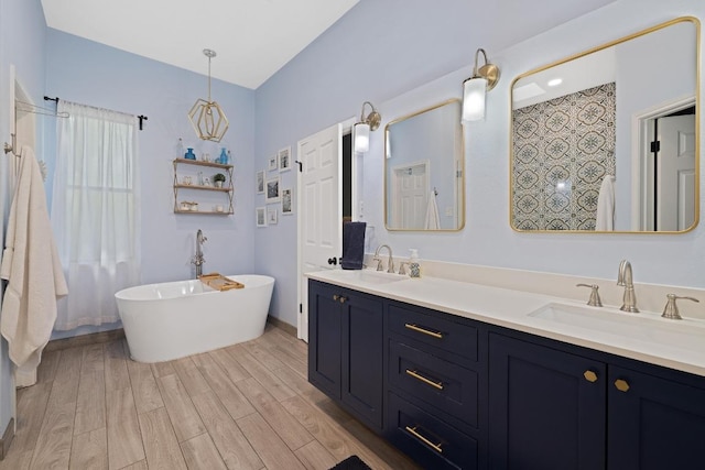 7303 Bluntleaf Cv, Austin, TX 78750 - bathroom with a freestanding bath, wood finished floors, and double vanity