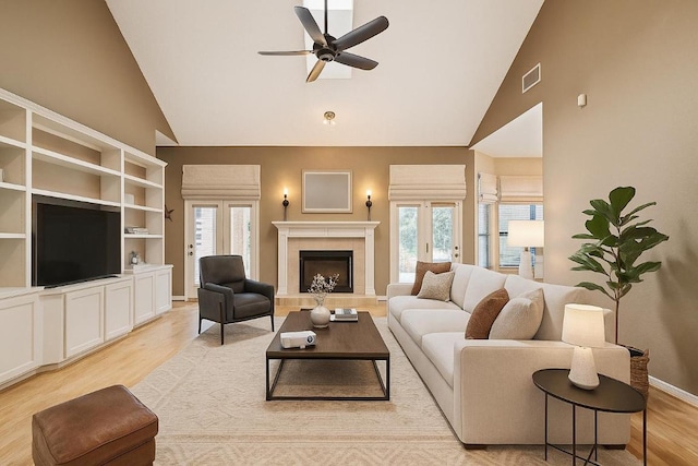 7303 Bluntleaf Cv, Austin, TX 78750 - living room with light wood-style floors, high vaulted ceiling, ceiling fan, plenty of natural light, and a fireplace