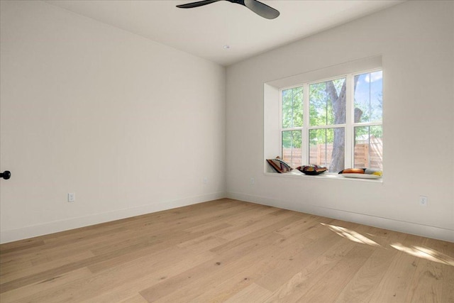 empty room featuring light wood-type flooring, baseboards, and ceiling fan