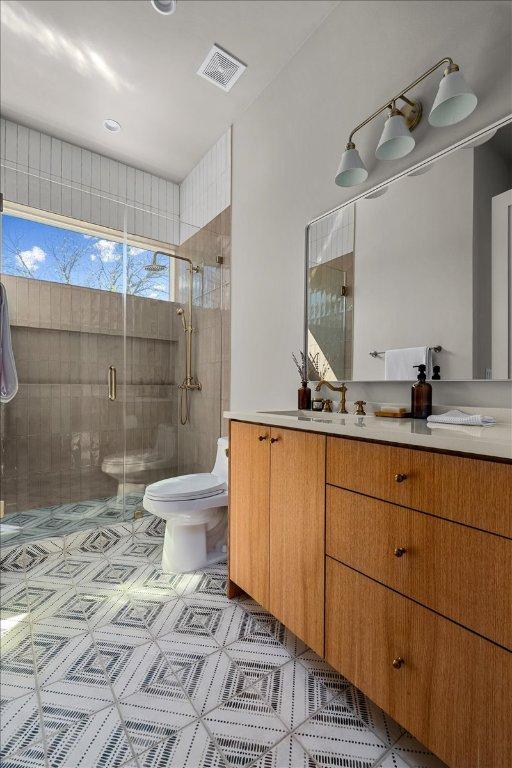 full bathroom featuring toilet, a shower stall, and vanity
