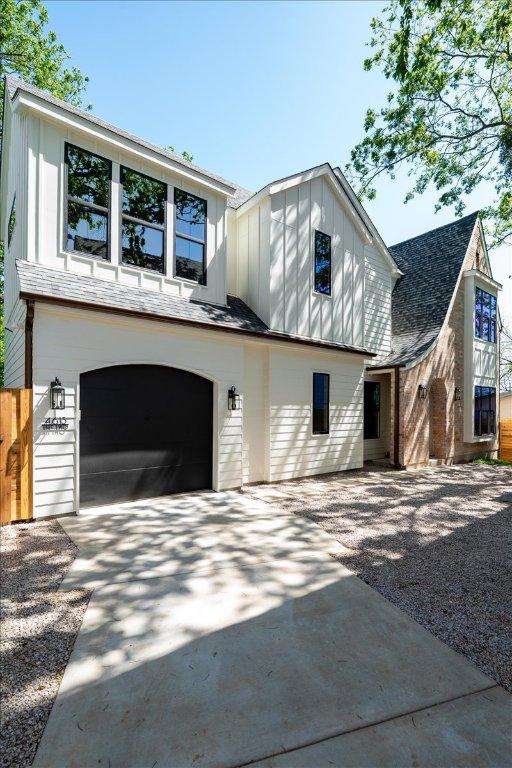 view of side of property featuring driveway, board and batten siding, and a garage
