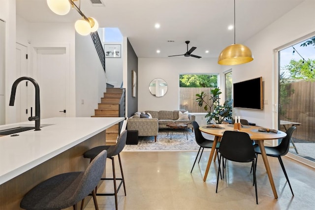4907 Delores Ave, Austin, TX 78721 - dining space featuring stairs, finished concrete flooring, a ceiling fan, and recessed lighting