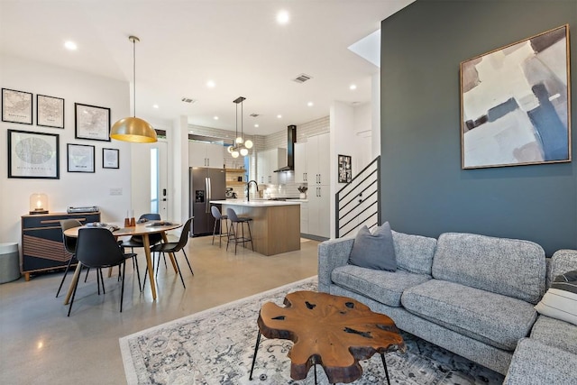 4907 Delores Ave, Austin, TX 78721 - living room featuring finished concrete floors, stairway, and recessed lighting