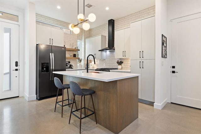 4907 Delores Ave, Austin, TX 78721 - kitchen featuring stainless steel fridge, concrete floors, wall chimney exhaust hood, a sink, and recessed lighting