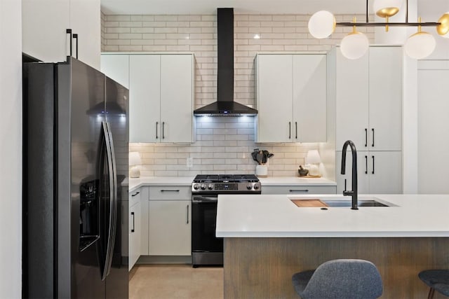 4907 Delores Ave, Austin, TX 78721 - kitchen with stainless steel appliances, wall chimney exhaust hood, a sink, light countertops, and a kitchen bar