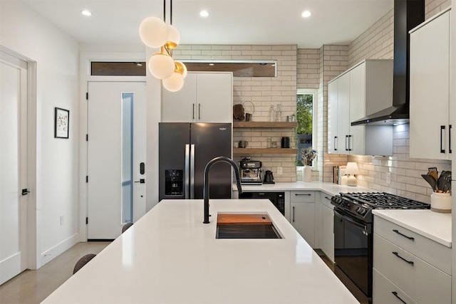 4907 Delores Ave, Austin, TX 78721 - kitchen featuring black range with gas stovetop, stainless steel fridge, backsplash, open shelves, and recessed lighting