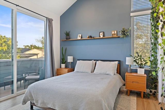 4907 Delores Ave, Austin, TX 78721 - bedroom with wood finished floors, access to outside, multiple windows, and vaulted ceiling