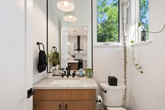 4907 Delores Ave, Austin, TX 78721 - bathroom with toilet, vanity, and tasteful backsplash