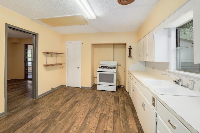300 W Cleveland St, Elgin, TX 78621 - kitchen with white gas range oven, dark wood-style floors, white cabinetry, a textured ceiling, and light countertops