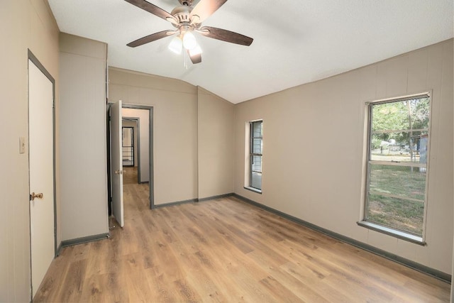 300 W Cleveland St, Elgin, TX 78621 - unfurnished bedroom with lofted ceiling, light wood finished floors, and a ceiling fan