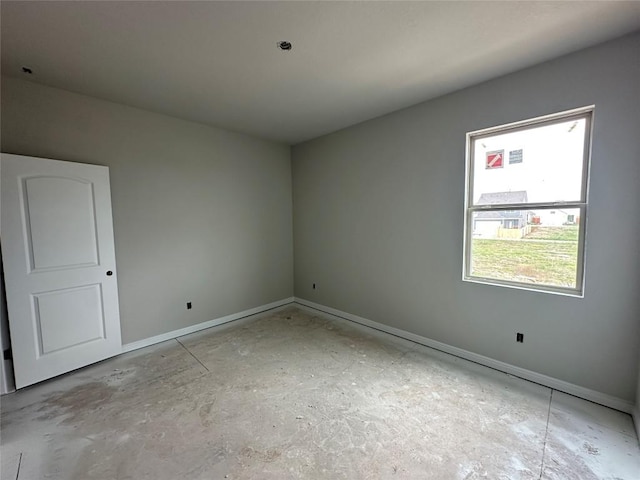 unfurnished room with baseboards