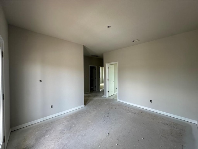 spare room with unfinished concrete floors and baseboards