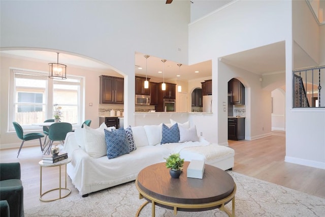 11721 Quintana Cv, Austin, TX 78739 - living room featuring arched walkways, light wood finished floors, ornamental molding, and baseboards