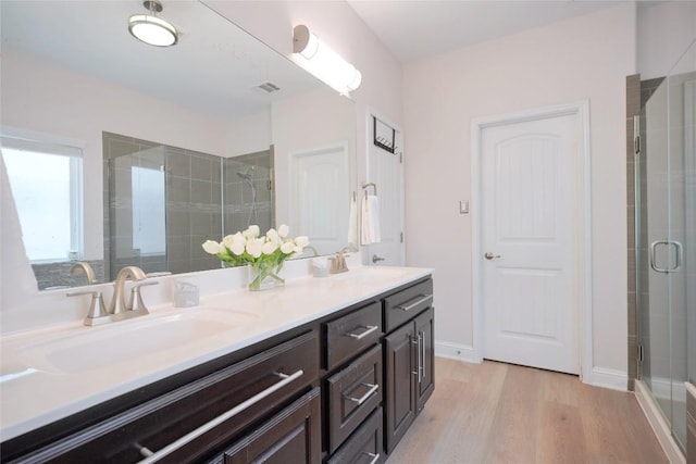 11721 Quintana Cv, Austin, TX 78739 - full bath with double vanity, a stall shower, and wood finished floors