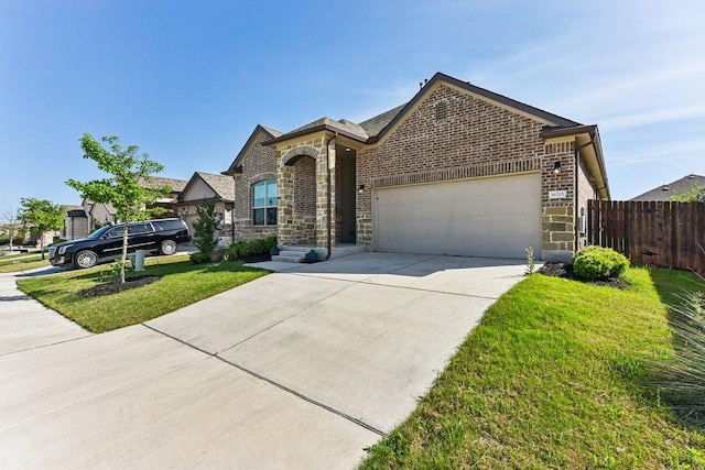 french provincial home featuring concrete driveway, a front lawn, an attached garage, fence, and brick siding