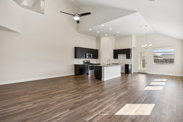 unfurnished living room featuring a sink, dark wood-style flooring, baseboards, ceiling fan with notable chandelier, and high vaulted ceiling
