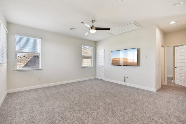 spare room with attic access, ceiling fan, light carpet, and baseboards