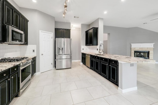 2616 Glenwood Trl, Cedar Park, TX 78613 - kitchen featuring appliances with stainless steel finishes, dark cabinetry, open floor plan, a peninsula, and recessed lighting