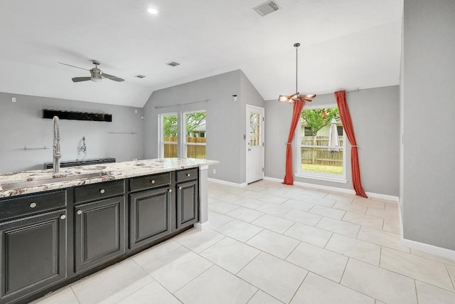 2616 Glenwood Trl, Cedar Park, TX 78613 - kitchen featuring lofted ceiling, ceiling fan, open floor plan, light stone counters, and baseboards