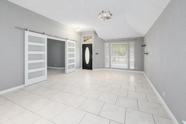 2616 Glenwood Trl, Cedar Park, TX 78613 - foyer with a barn door, light tile patterned floors, and baseboards