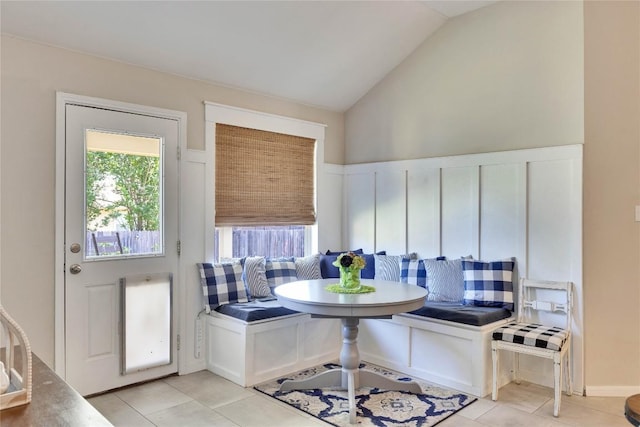 dining area with light tile patterned floors and lofted ceiling