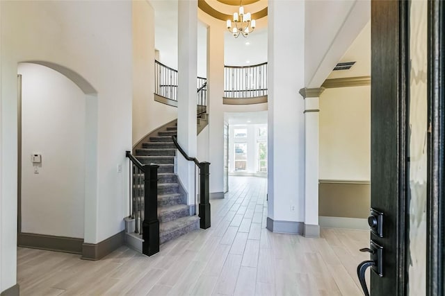 18705 Alonso Pl, Austin, TX 78738 - entryway featuring a chandelier, wood finished floors, stairs, a towering ceiling, and arched walkways