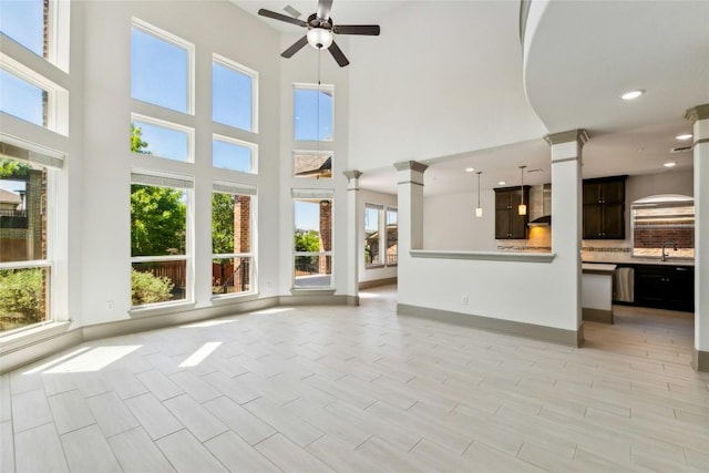 18705 Alonso Pl, Austin, TX 78738 - unfurnished living room featuring ornate columns, healthy amount of natural light, a ceiling fan, a high ceiling, and recessed lighting