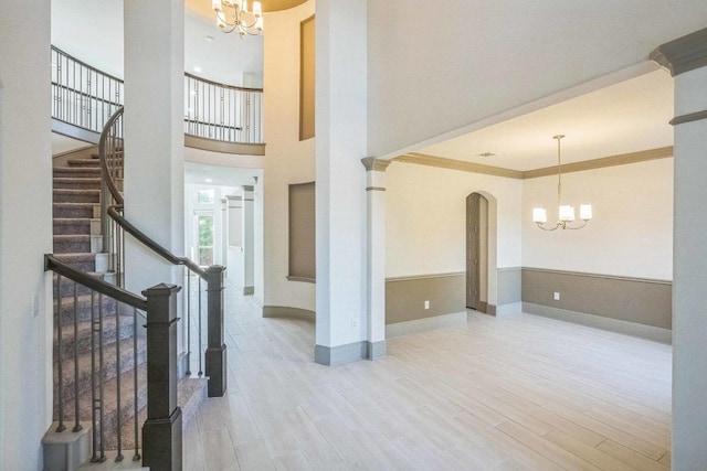 18705 Alonso Pl, Austin, TX 78738 - foyer entrance with a chandelier, wood finished floors, arched walkways, stairs, and a high ceiling