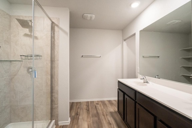 bathroom with a stall shower, wood finished floors, and vanity