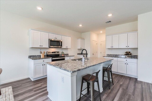 196 Thistle Ln, Maxwell, TX 78656 - kitchen with stainless steel appliances, a sink, dark wood finished floors, a center island with sink, and recessed lighting