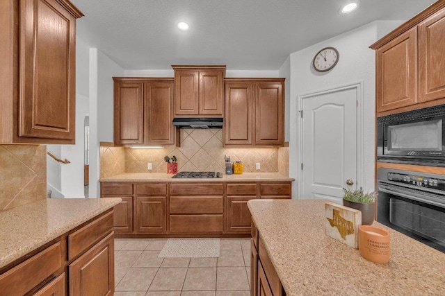 1107 Shiloh St, Cedar Park, TX 78613 - kitchen featuring black microwave, oven, under cabinet range hood, stainless steel gas cooktop, and tasteful backsplash