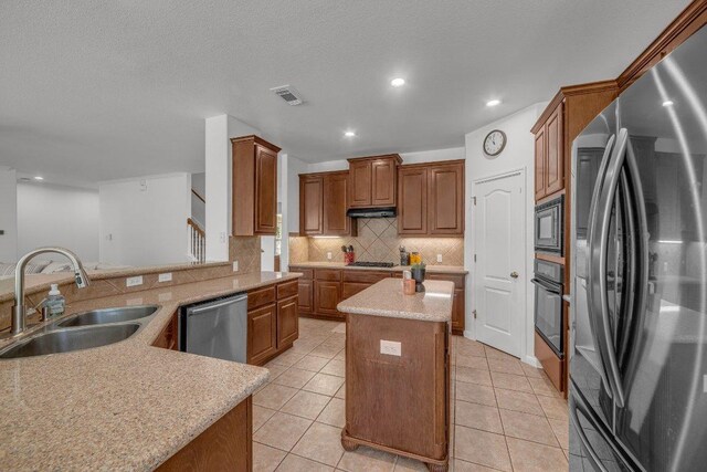 1107 Shiloh St, Cedar Park, TX 78613 - kitchen featuring stainless steel appliances, a sink, a center island, backsplash, and light tile patterned floors
