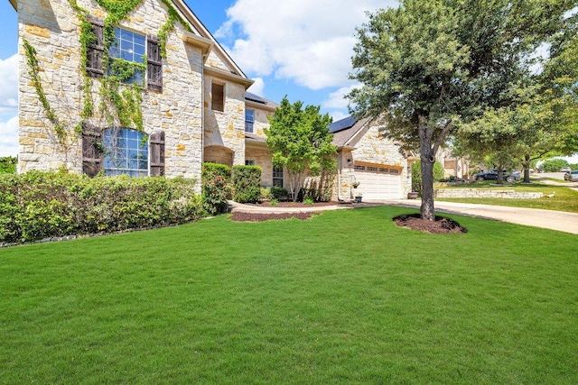 1107 Shiloh St, Cedar Park, TX 78613 - view of front of property with stone siding, a front lawn, concrete driveway, and roof mounted solar panels