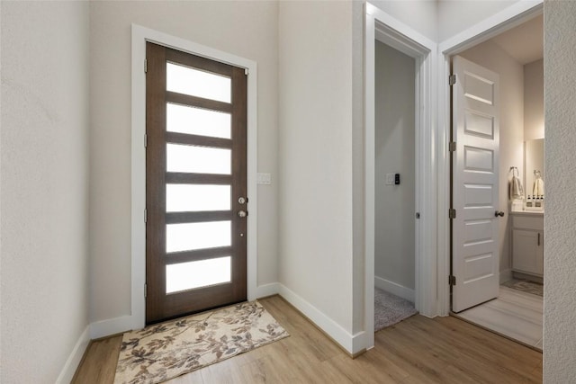 entrance foyer featuring light wood-style floors, healthy amount of natural light, and baseboards
