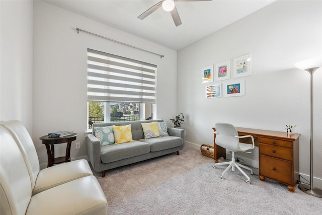 carpeted office space with ceiling fan and baseboards