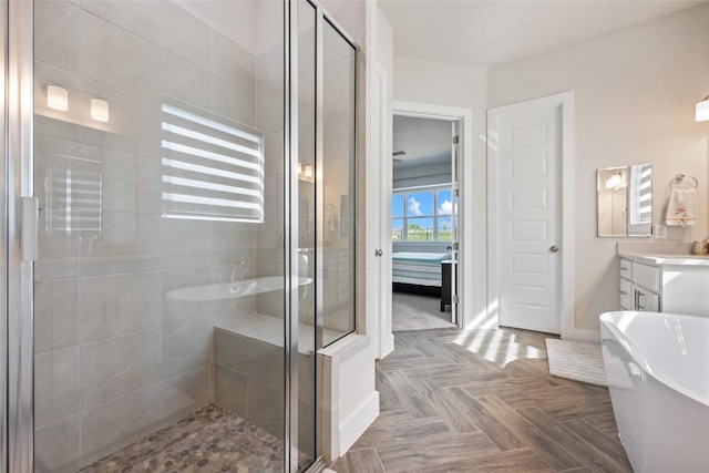 full bath with a stall shower, a soaking tub, and vanity