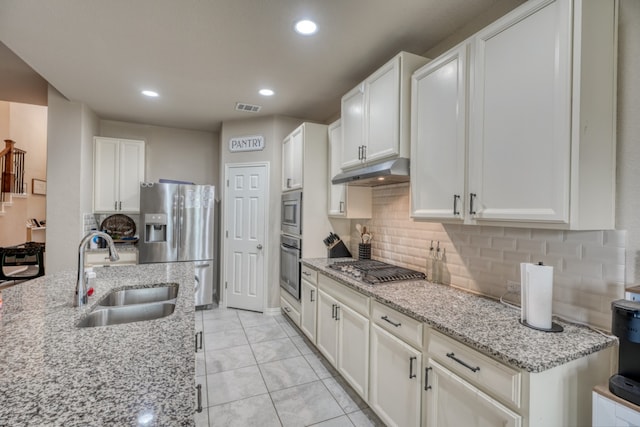 5917 Moriano Cv, Round Rock, TX 78665 - kitchen featuring a sink, appliances with stainless steel finishes, under cabinet range hood, backsplash, and white cabinetry