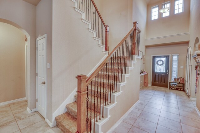 5917 Moriano Cv, Round Rock, TX 78665 - foyer entrance with a high ceiling, arched walkways, tile patterned flooring, and stairway