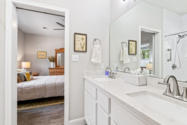 ensuite bathroom with tiled shower, a sink, and connected bathroom